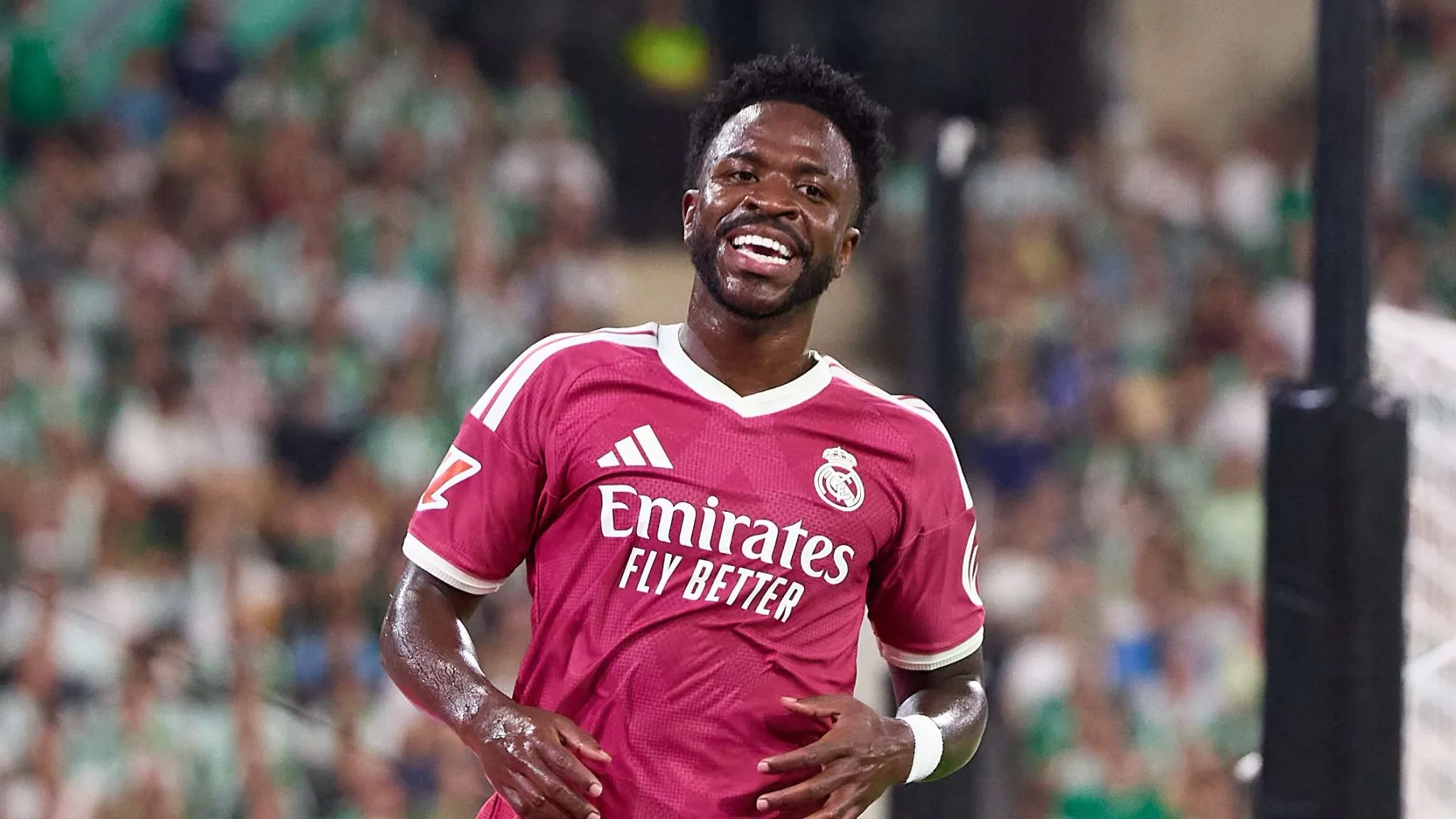 لاعب ريال مدريد فينيشيوس جونيور مبتسم خلال مباراة، يعكس نجاح وكالة Roc Nation Sports في تمديد عقده وتأثيرها في كرة القدم الأوروبية.