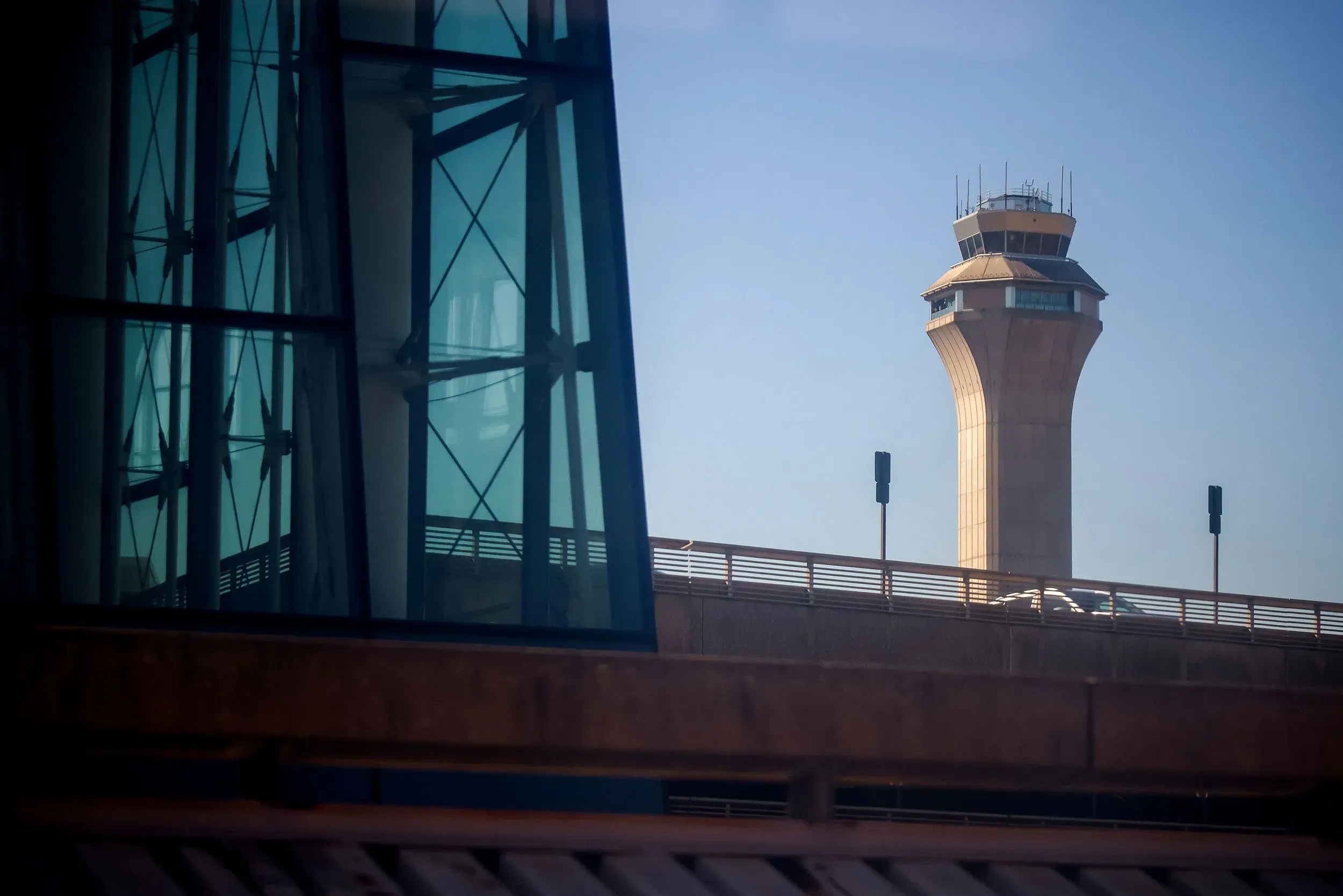 تظهر الصورة برج مراقبة الحركة الجوية في مطار، مع خلفية زجاجية حديثة. تعكس الأوضاع الحالية نقص الموظفين وتأثير الإغلاق الحكومي على سلامة السفر الجوي.