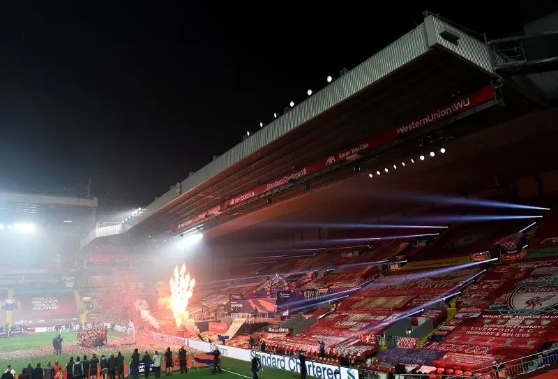 إضاءة مبهرة في ملعب أنفيلد، حيث يتجمع مشجعو ليفربول في احتفال بعيد عن الأجواء المعتادة، مع شعارات النادي تملأ المدرجات.