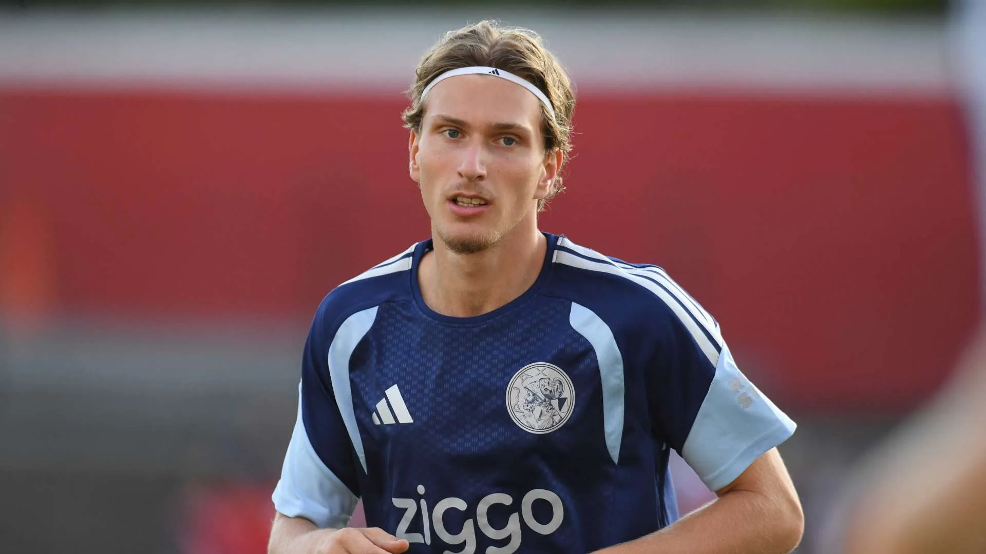 لاعب كرة قدم شاب يرتدي زي أجاكس الهولندي خلال تدريباته، مرتبط بمفاوضات ليفربول لضم باركولا من باريس سان جيرمان.