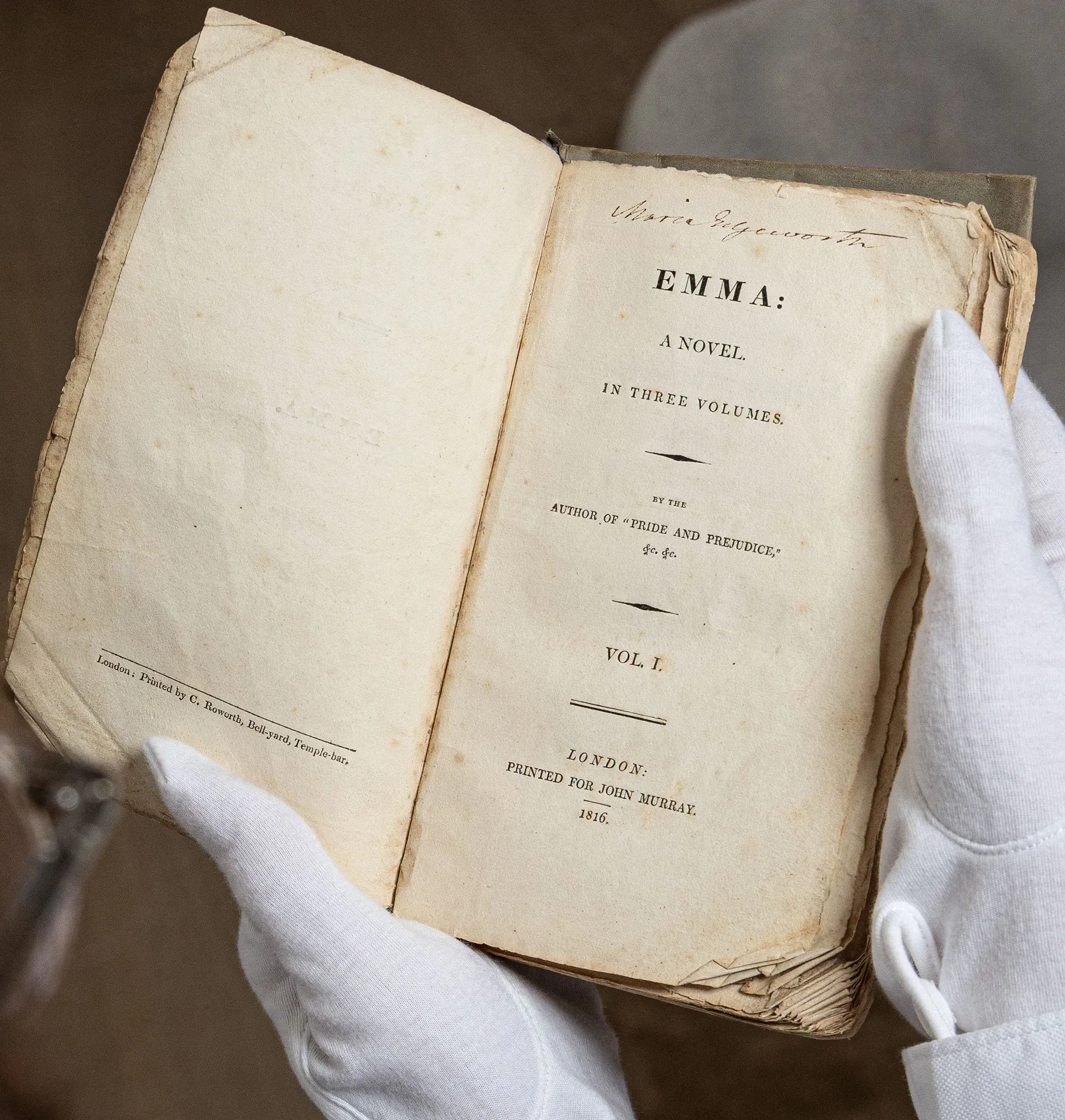 نسخة قديمة من رواية "إيما" لجين أوستن، تظهر العنوان والمعلومات الطباعية، مع تفاصيل تبرز حالة الكتاب.