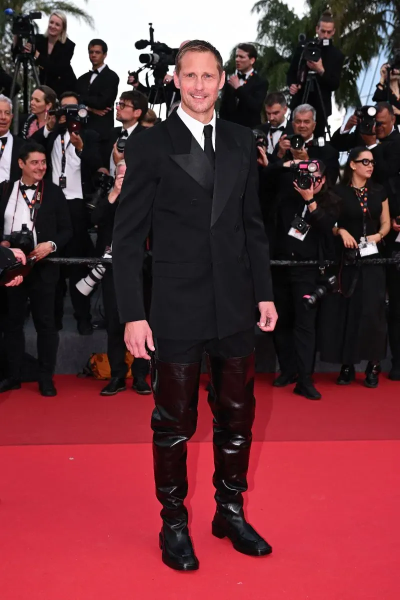 ألكسندر سكارسغارد يرتدي حذاءً جلديًا طويلًا يصل إلى الفخذ في مهرجان كان السينمائي، مما يثير النقاش حول الأزياء الجريئة.