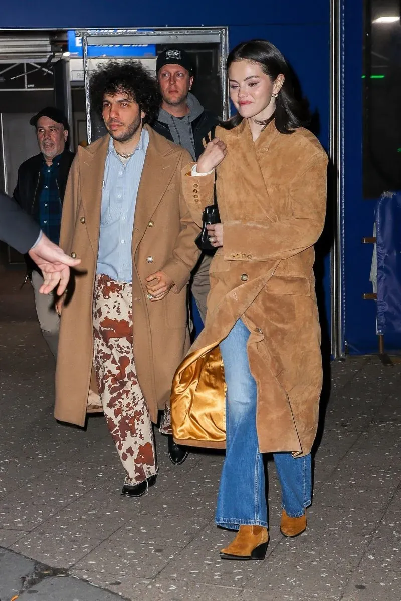 سيلينا غوميز وبيني بلانكو يتألقان بإطلالات منسقة بمعاطف بلون الجمل، حيث ارتدت غوميز بنطلون جينز وحقيبة سوداء بينما ارتدى بلانكو بنطلوناً مطبوعاً.