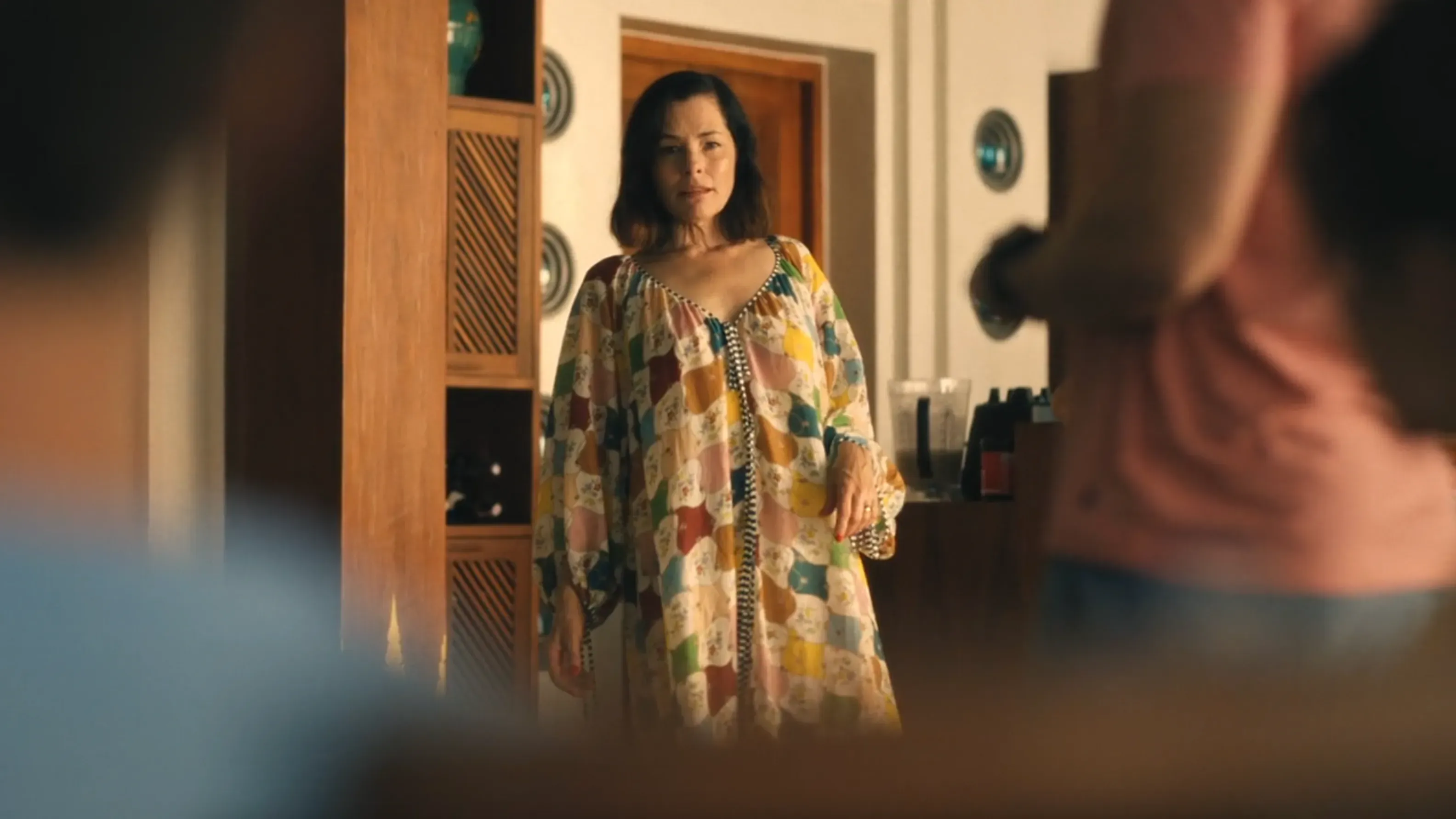 فيكتوريا راتليف، مرتدية فستان ملون، تبدو قلقة وهي تستجوب أطفالها حول اللورازيبام المفقود في مشهد من مسلسل "اللوتس الأبيض".