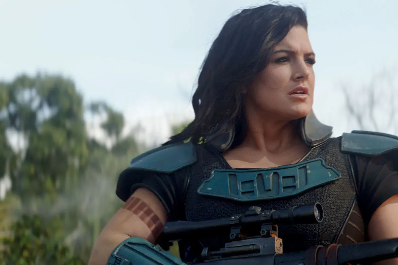 جينا كارانو في دورها كارا ديون بمسلسل "الماندالوريان"، مرتدية درعًا قتاليًا وتحمل سلاحًا، تعكس شخصيتها القوية في عالم "حرب النجوم".