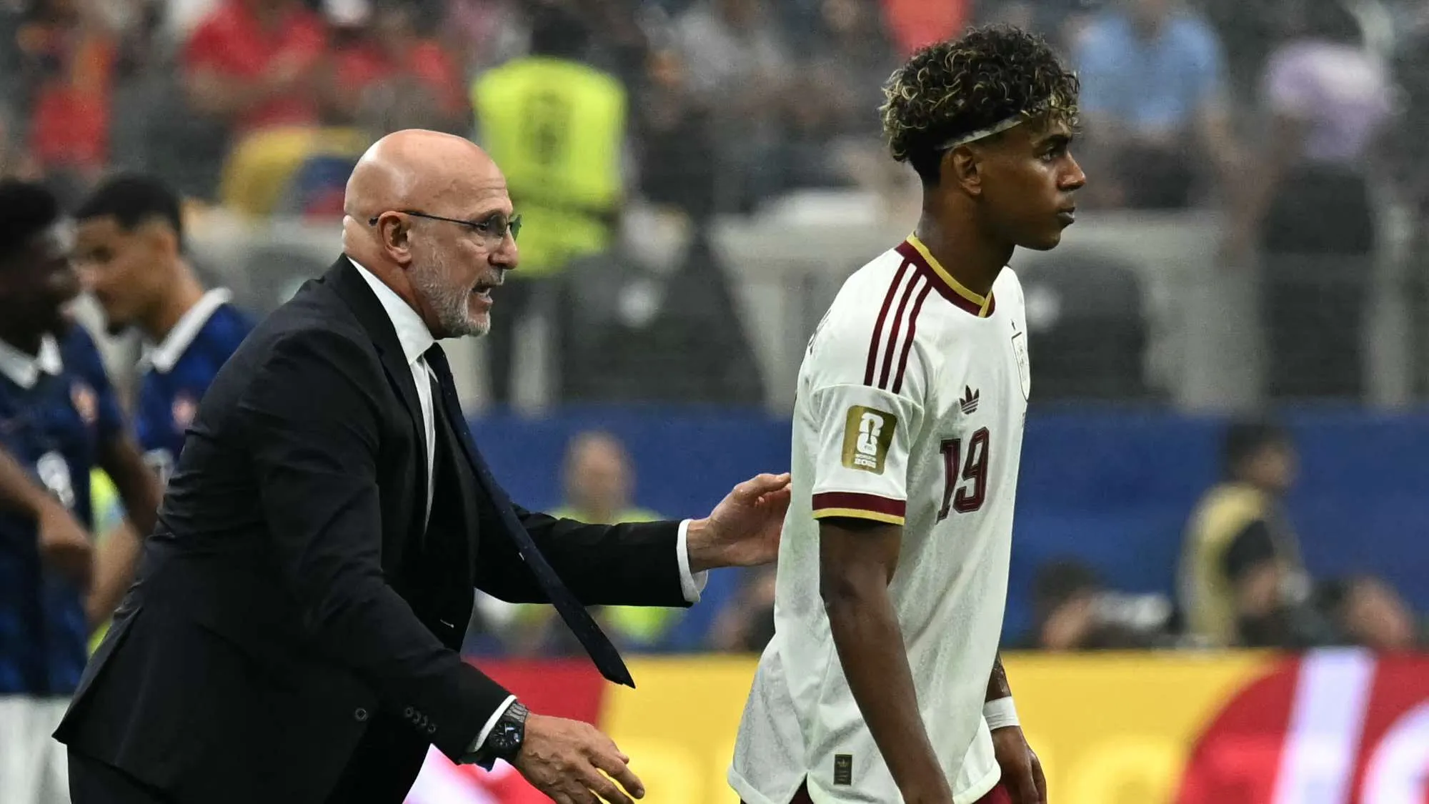 المدرب لويس دي لا فوينتي يواسي اللاعب لامين يمال أثناء خروجه من ملعب نصف نهائي كأس العالم بعد إصابة طفيفة.