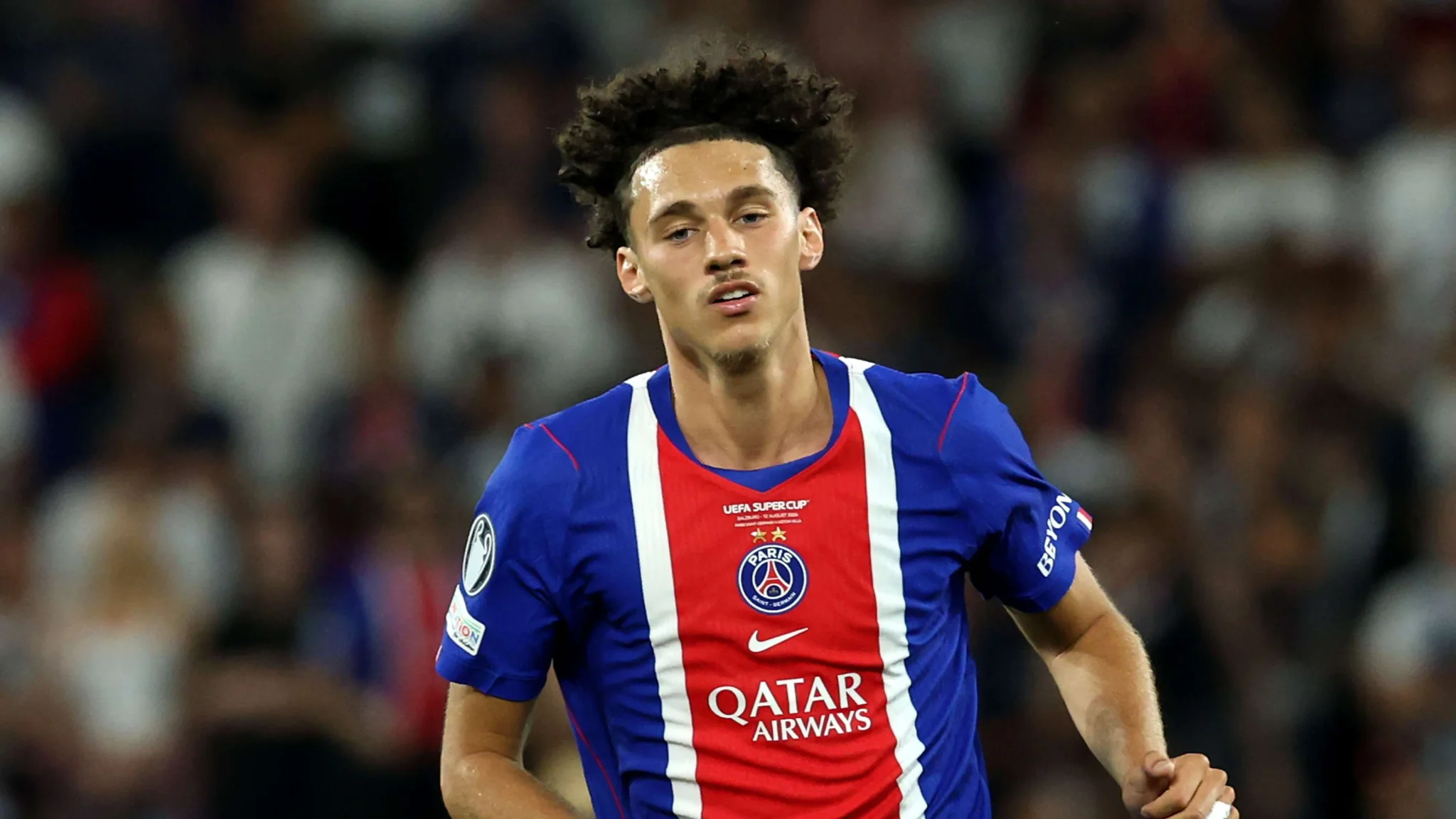 لاعب باريس سان جيرمان مغنس أكليوش يرتدي زي الفريق الأزرق والأحمر خلال مباراة دوري أبطال أوروبا، مع تركيز على دوره التكتيكي والدفاعي.
