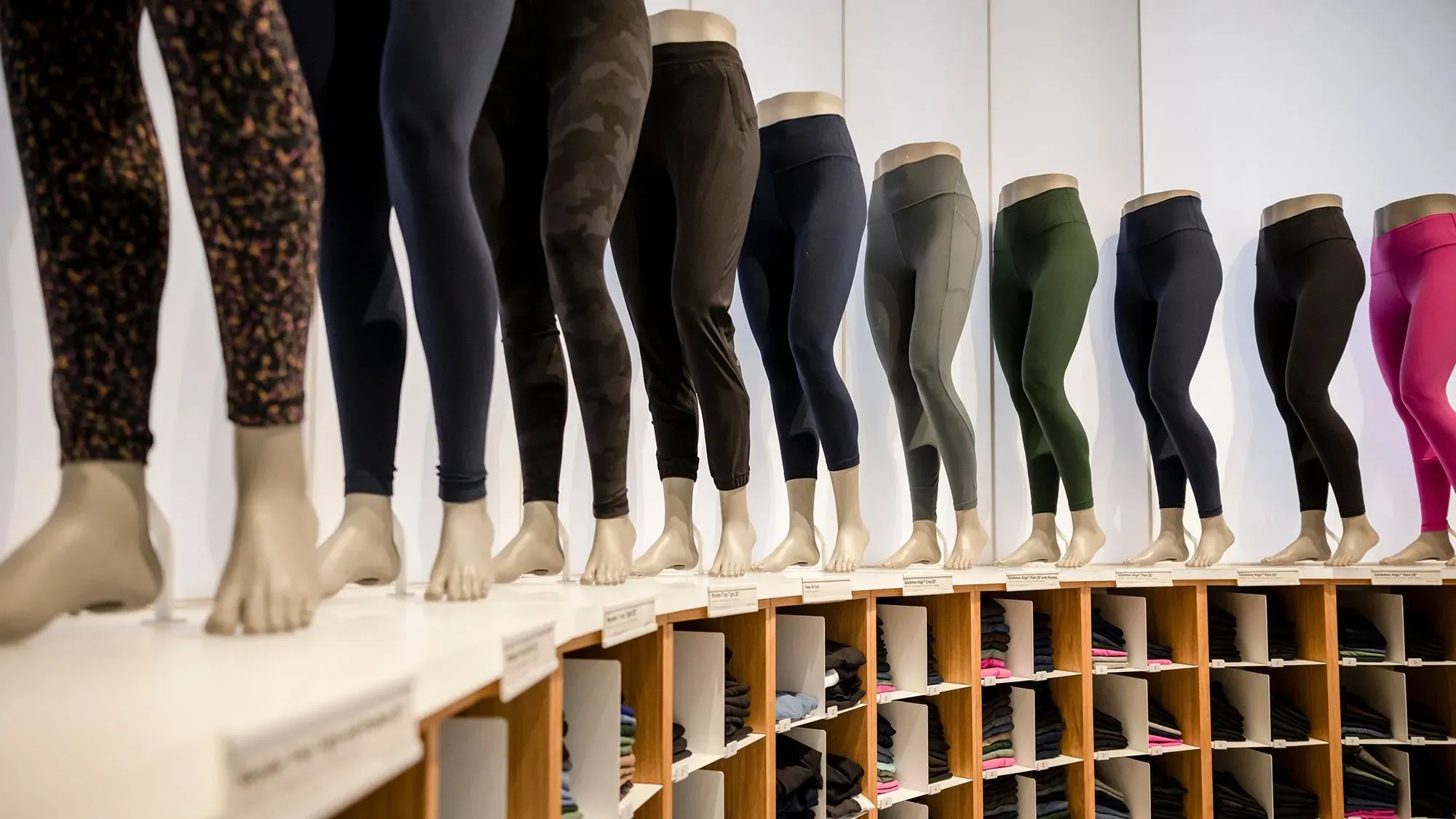 سراويل رياضية ملونة معروضة على دمى في متجر، تمثل منتجات لولوليمون التي تتعرض للقرصنة من قبل كوستكو.