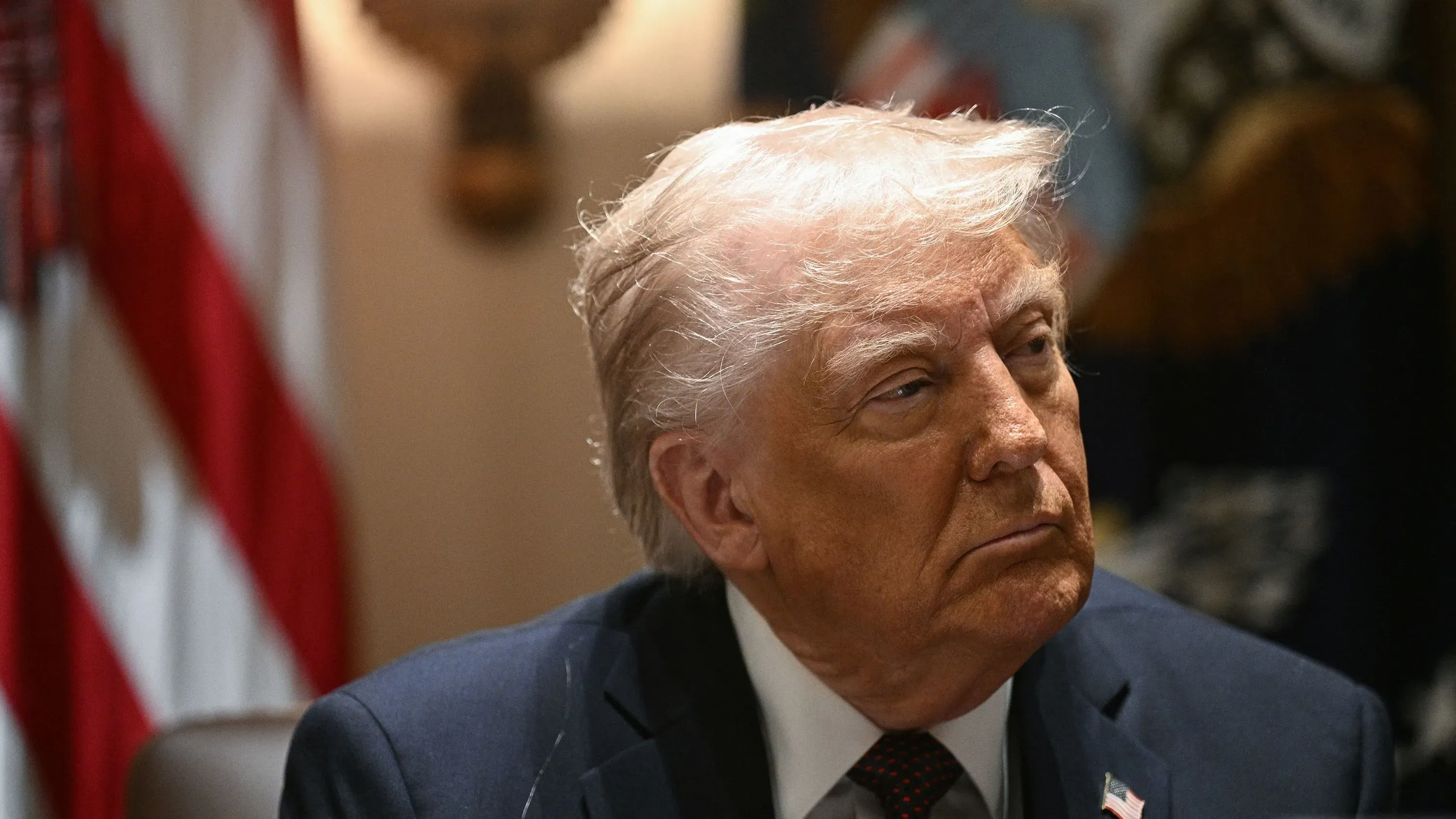 دونالد ترامب أثناء اجتماع رسمي، مع العلم الأمريكي خلفه، حيث يتحدث عن مشاريعه التجارية في الشرق الأوسط.