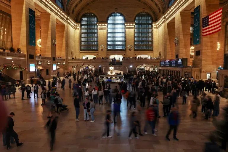 محطة Grand Central في نيويورك، مزدحمة بالمسافرين، مع تفاصيل معمارية باروكية كلاسيكية، تبرز كوجهة سياحية رئيسية.