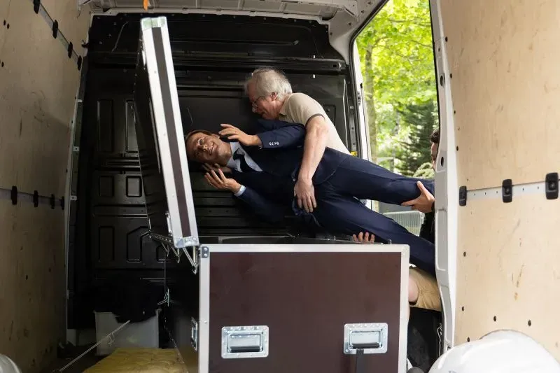 نشطاء يحملون تمثال إيمانويل ماكرون داخل شاحنة، احتجاجًا على سياساته التجارية والبيئية، مع التركيز على التحديات المناخية.