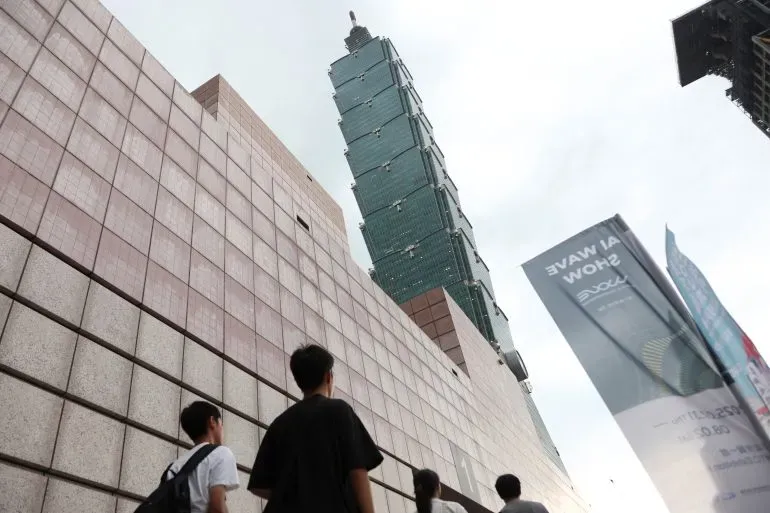 مارة يتجهون نحو برج تايبيه 101، أحد المعالم الشهيرة في العاصمة تايبيه، بعد زلزال بقوة 6 درجات قبالة الساحل الشمالي الشرقي لتايوان.