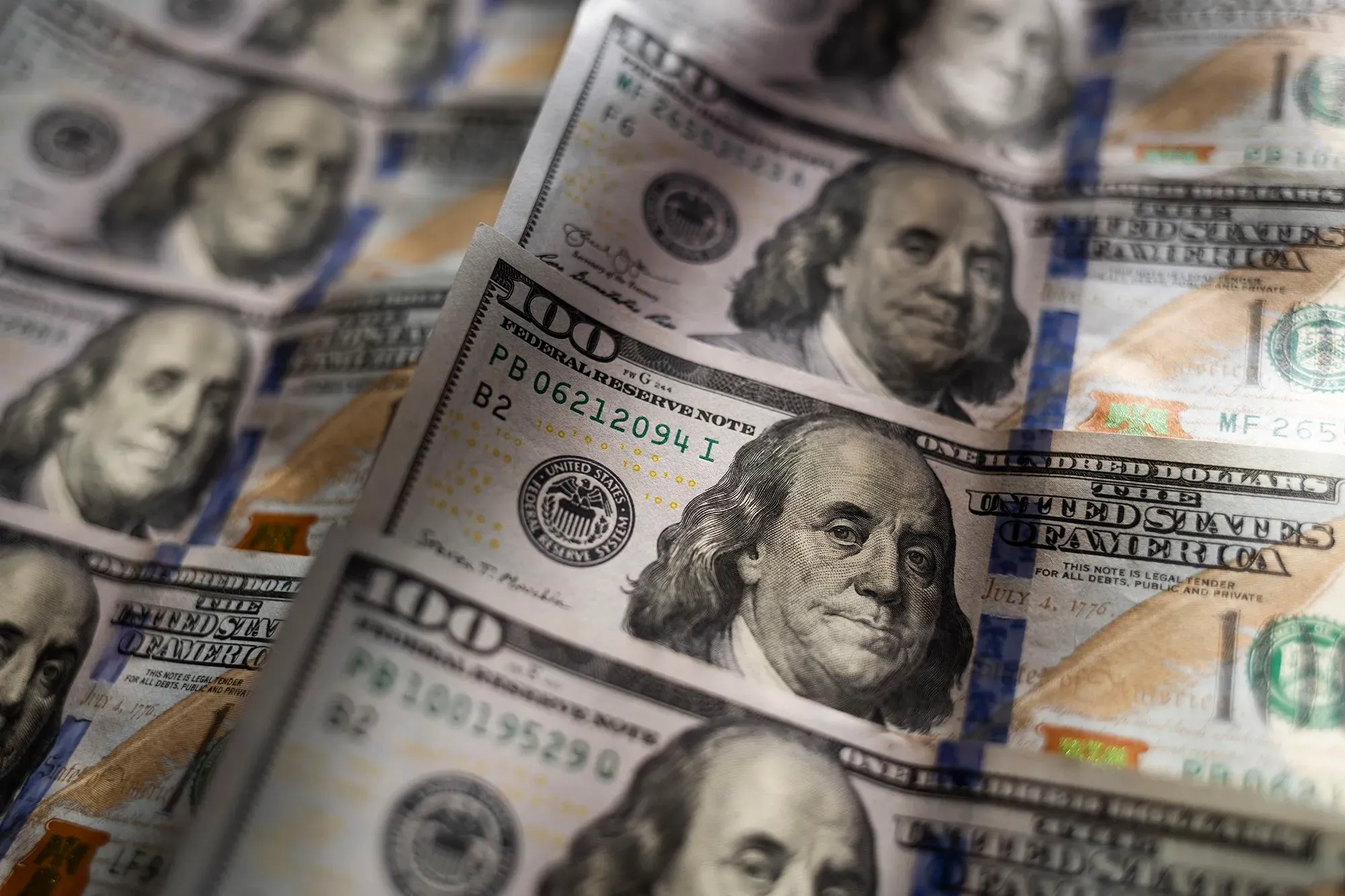 صورة تظهر مجموعة من أوراق الدولار الأمريكي، تركز على فئة المئة دولار، مما يعكس موضوع استراتيجيات الاستثمار والحفاظ على رأس المال.