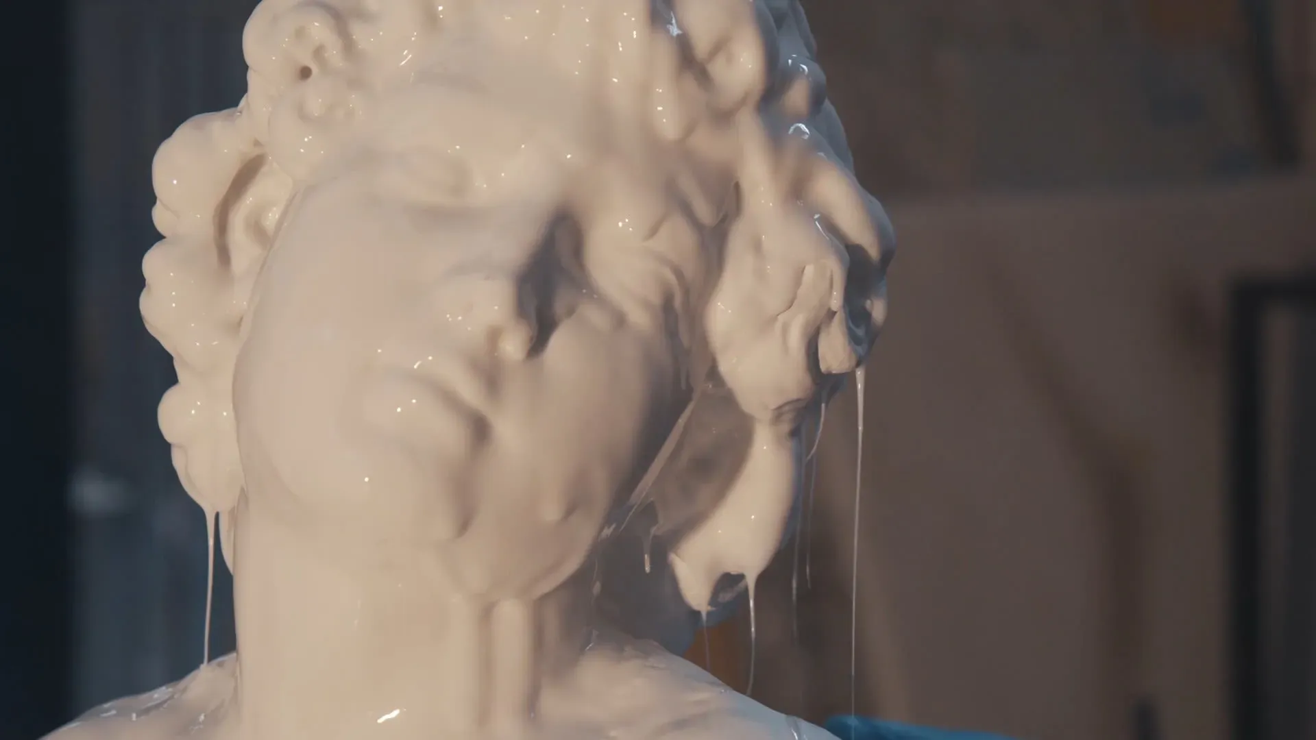 نسخة من منحوتة مايكل أنجلو، تظهر ملامح وجه تمثال مغمور في مادة سائلة، تعكس تقنيات الطباعة ثلاثية الأبعاد المستخدمة في المعرض.