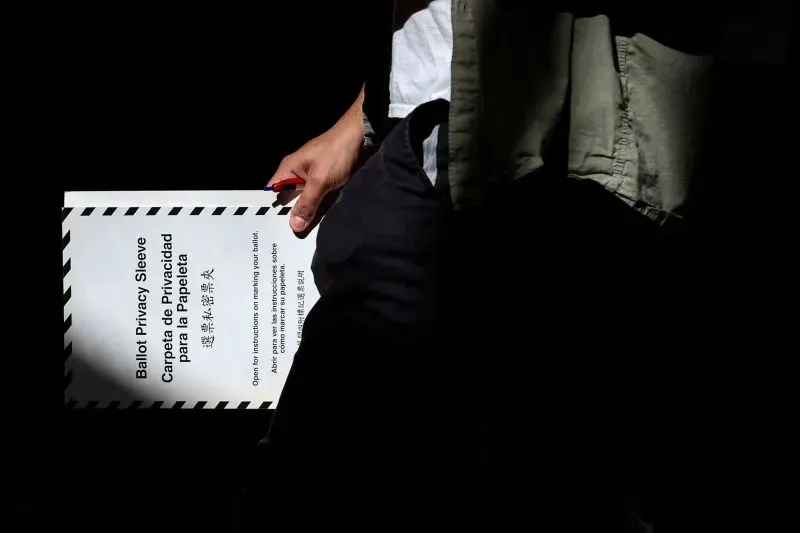 شخص يحمل مظروف بطاقات الاقتراع مكتوب عليه "حماية الخصوصية للبطاقة" أثناء انتظار نتائج الانتخابات التمهيدية لعمدة نيويورك.