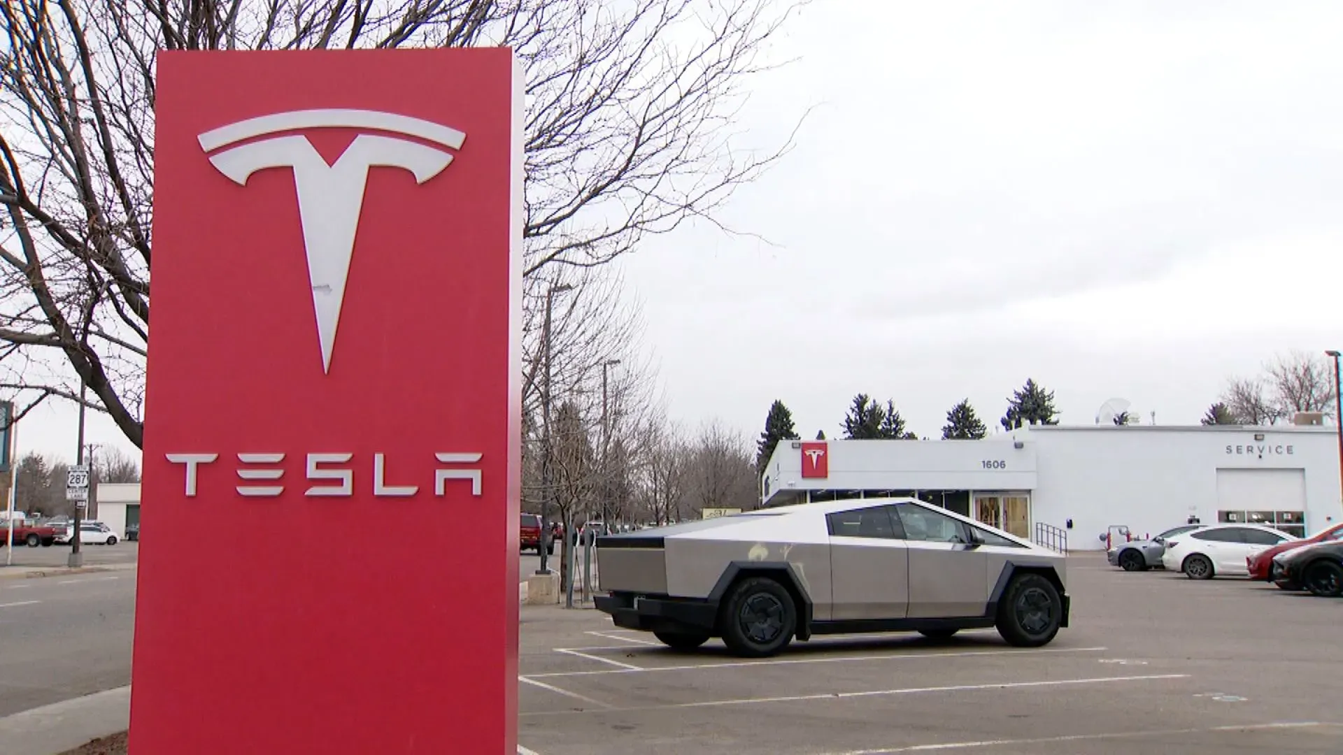علامة تسلا الحمراء مع سيارة تسلا سايبرترك في موقف سيارات، تشير إلى موقع الهجوم على وكالة تسلا في كولورادو.
