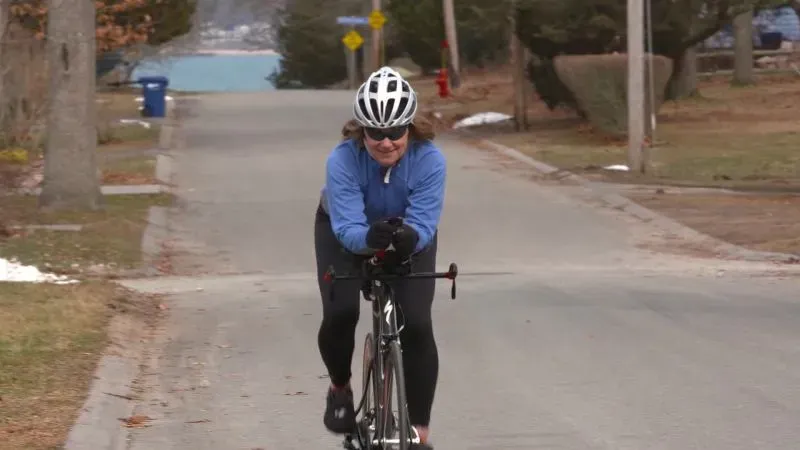 امرأة ترتدي خوذة دراجة وتدرب في الشارع، تعكس روح النشاط والحيوية، مما يعزز أهمية الصحة البدنية في سياق تقنيات القلب الاصطناعي.