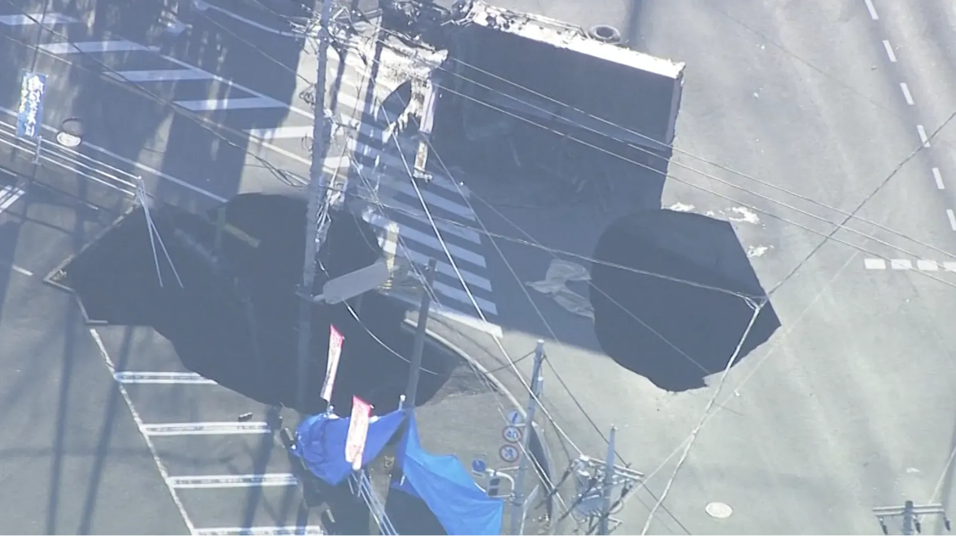 حفرة كبيرة في الطريق بالقرب من طوكيو، مع تسجيل الأضرار الناجمة عن انهيار الأرض، حيث سقطت شاحنة فيها، مما أدى إلى إجراء عمليات إنقاذ.