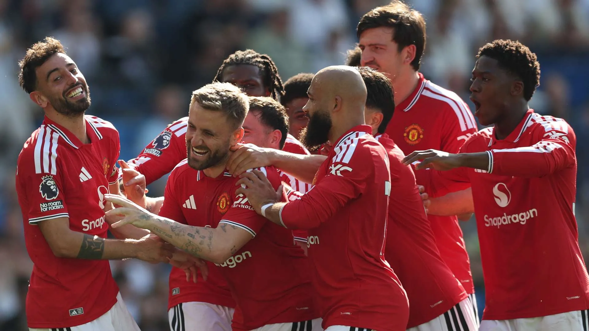 لاعبو مانشستر يونايتد يحتفلون معاً خلال مباراة في الدوري الإنجليزي الممتاز، مع التركيز على عودة الفريق للمنافسة بقوة في الموسم الجديد.