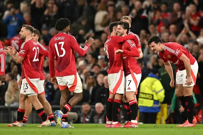 لاعبو مانشستر يونايتد يحتفلون بعد تحقيق الفوز في مباراة نصف النهائي، مع التركيز على الأجواء الإيجابية قبل نهائي الدوري الأوروبي.