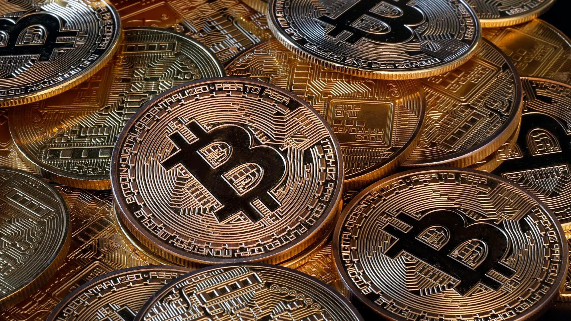 عملات البيتكوين المعدنية تتراص فوق بعضها، مع تفاصيل دقيقة على السطح، تمثل الأصول الرقمية التي ستخضع لمتطلبات الإبلاغ الضريبي.