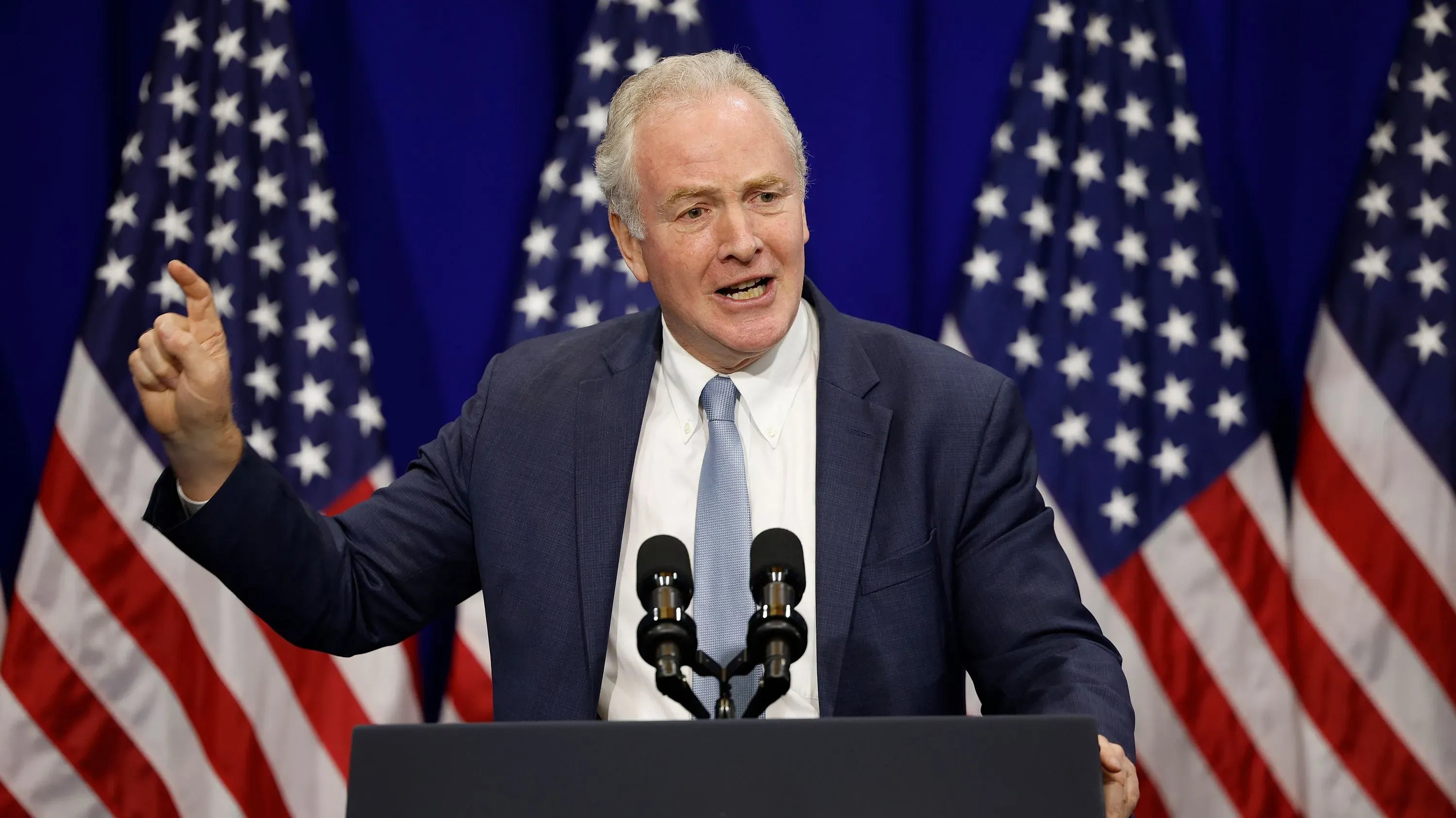 السيناتور كريس فان هولين يتحدث أمام خلفية من الأعلام الأمريكية، معبرًا عن دعمه لجهود إطلاق سراح كيلمار أبريغو غارسيا.