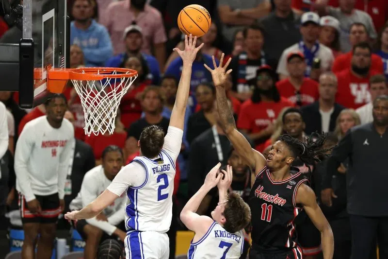 لاعب كرة السلة كوبر فلاج يسجل نقطة خلال مباراة حاسمة، بينما يحاول لاعب آخر من فريق هيوستن صد الكرة.