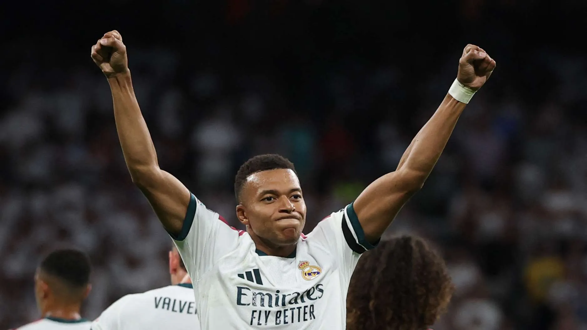 كيليان مبابي لاعب ريال مدريد يرفع يديه احتفالاً في مباراة قبل مواجهة رايو فاليكانو، مع التركيز على دوره كمهاجم بارز.