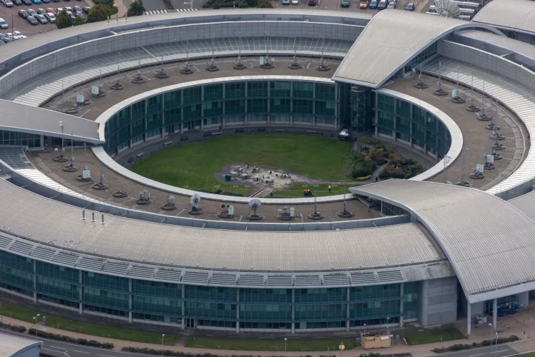 مقرّ جهاز التجسّس الإلكتروني البريطاني GCHQ في Bletchley Park، يظهر تصميمه الدائري الحديث مع مرافق خدمية وحديقة داخلية.
