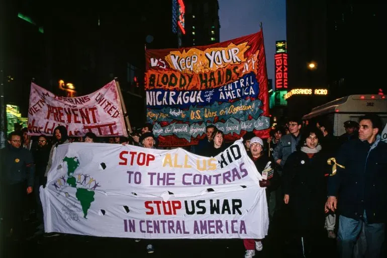 مظاهرة في مدينة نيويورك ضد التدخلات الأمريكية في أمريكا الوسطى، مع لافتات تطالب بوقف الدعم للحرب في نيكاراغوا.