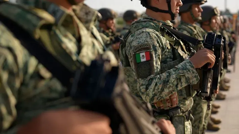 جنود مكسيكيون يرتدون زيًا عسكريًا، يحملون أسلحة، ويقفون في صفوف أثناء استعدادهم لمواجهة تهديدات الكارتلات.