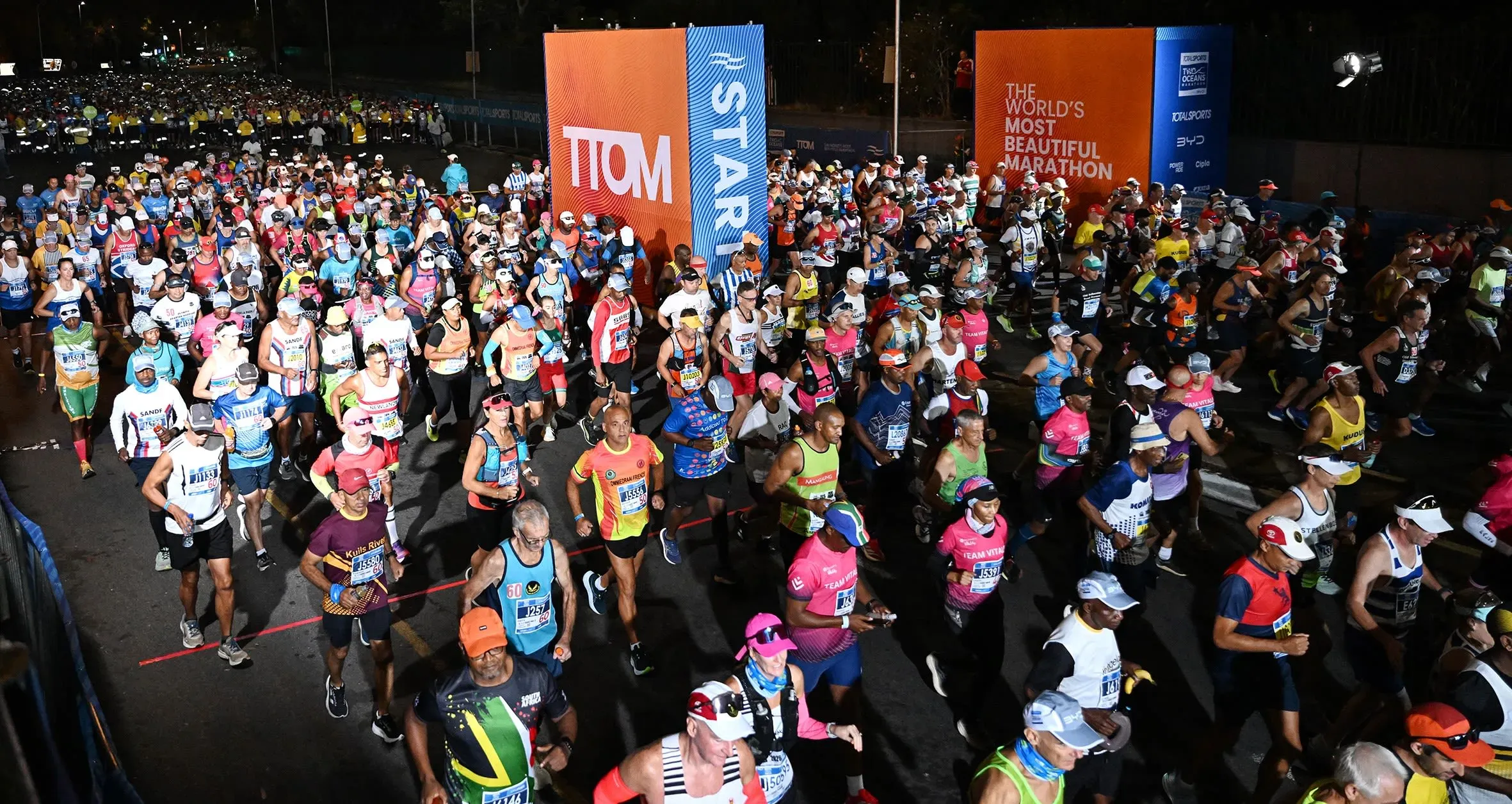 مئات العدائين يتجهون نحو خط البداية في سباق Two Oceans Marathon بكاب تاون، حيث يتنافسون في حدث رياضي شهير.