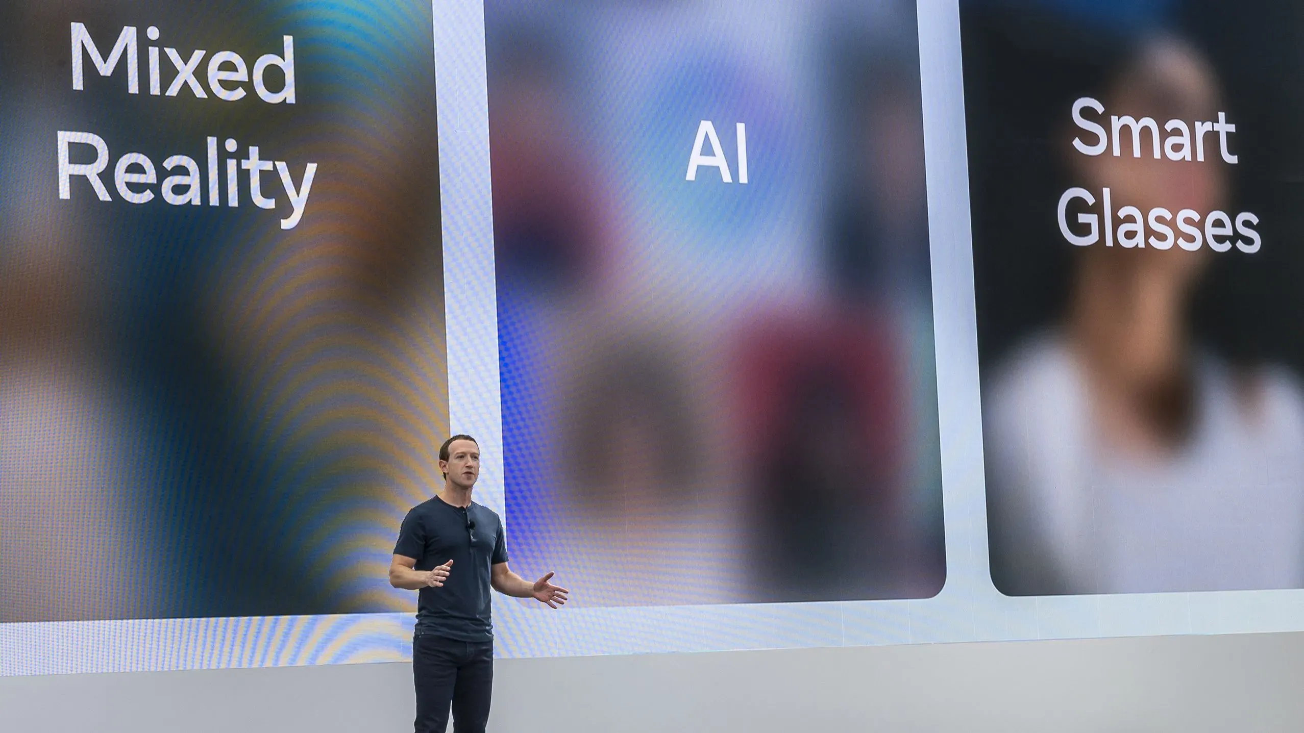 مارك زوكربيرج يتحدث في حدث حول تقنيات الواقع المختلط والذكاء الاصطناعي والنظارات الذكية، مع عرض نصوص توضيحية خلفه.