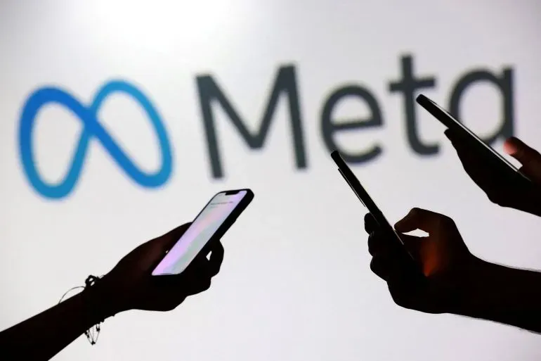 تظهر الصورة أيادي تحمل هواتف ذكية أمام شعار شركة Meta، مما يعكس التركيز على التكنولوجيا والابتكار في مجال الذكاء الاصطناعي.