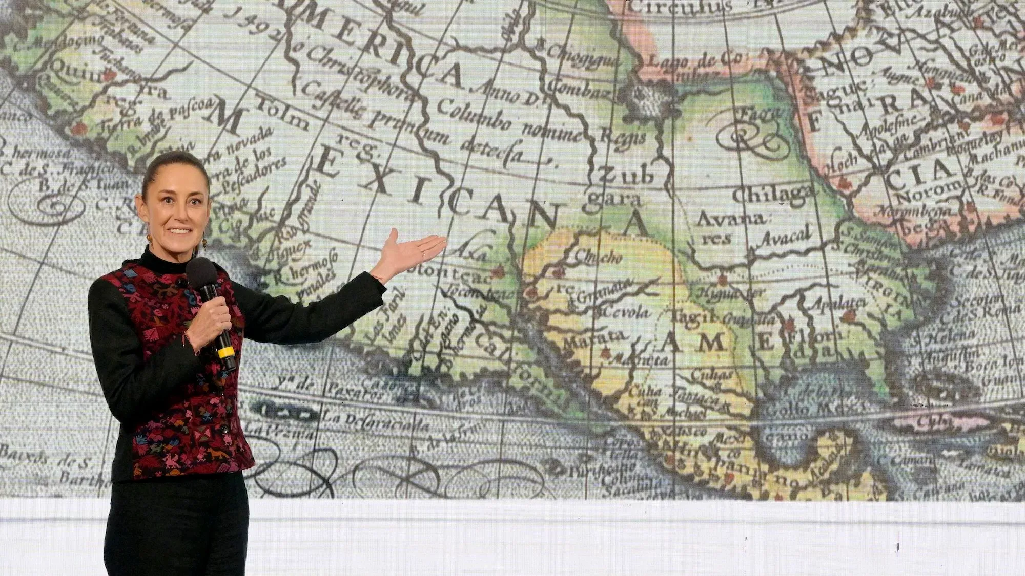 شينباوم تتحدث في مؤتمر صحفي، مشيرةً إلى خريطة قديمة تُظهر "خليج المكسيك"، وسط جدل حول تسميته بـ"خليج أمريكا".