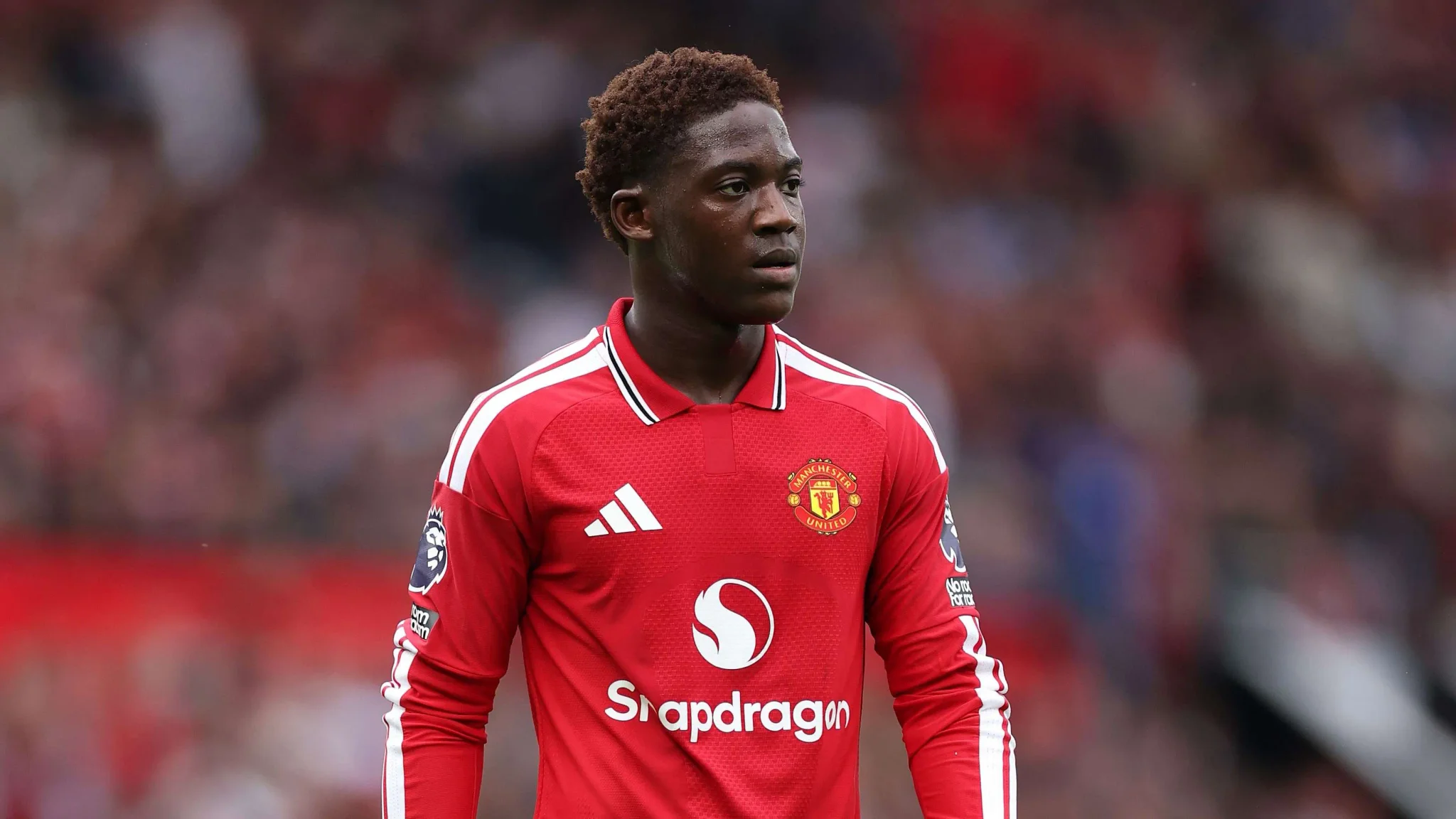 لاعب وسط مانشستر يونايتد كوبّي ماينو يرتدي الزي الأحمر خلال مباراة في الدوري الإنجليزي، مع تركيز على أدائه المتطور والمنافسة القوية في الفريق.