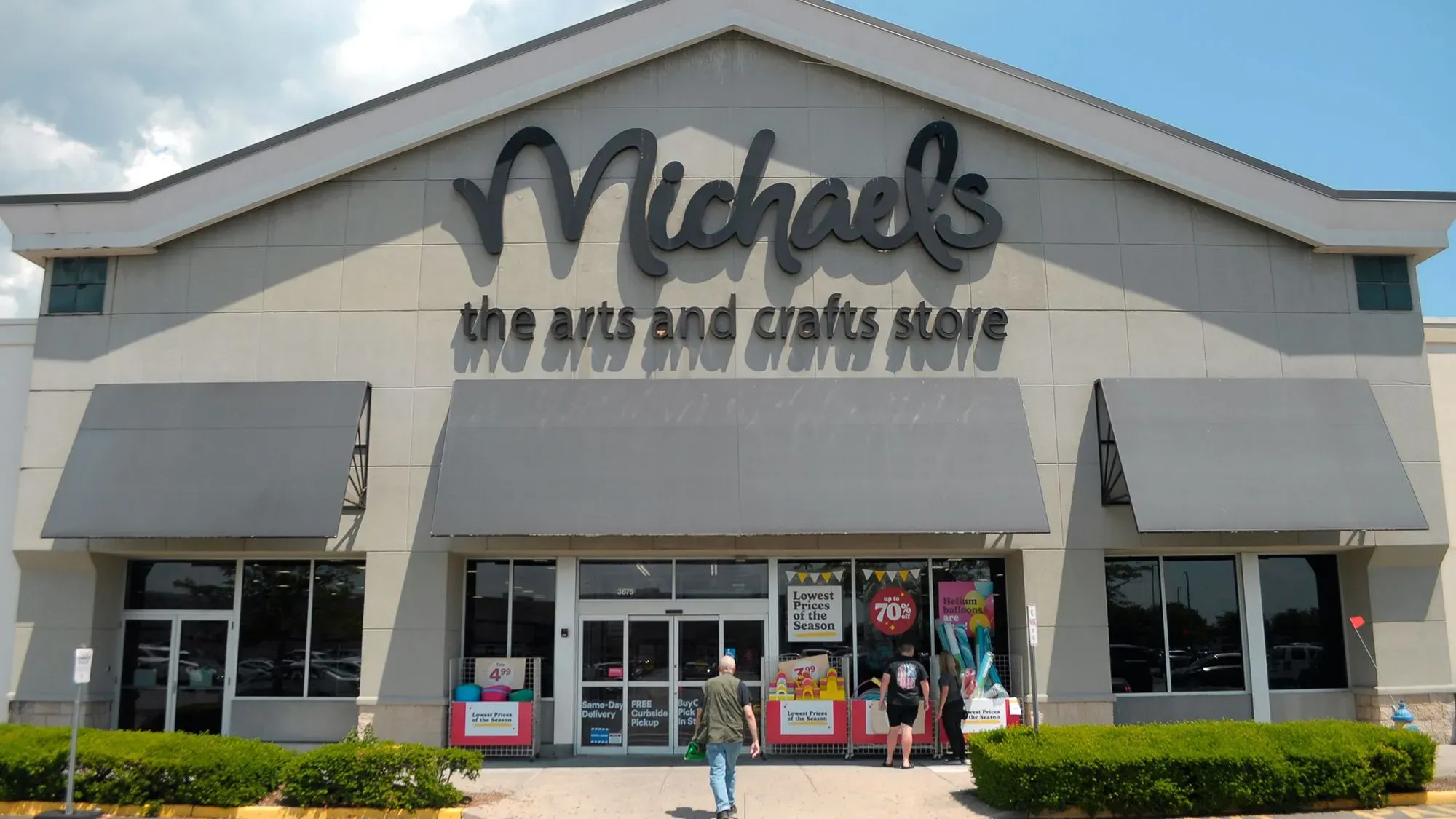 واجهة متجر مايكلز للأعمال الفنية والحرفية، مع لافتة بارزة تحمل اسم المتجر، حيث يتسوق الزبائن في جو مفعم بالإبداع.