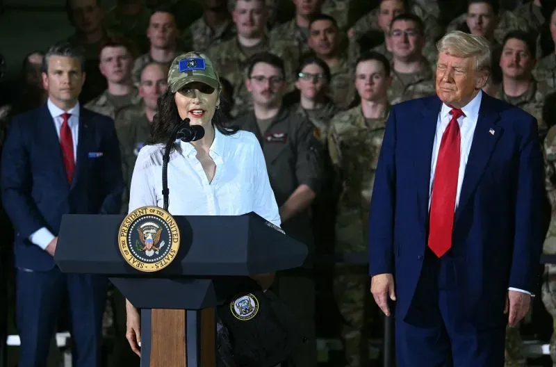 حاكمة ميشيغان غريتشن ويتمير تتحدث أمام حشد من الجنود، بينما يقف الرئيس ترامب خلفها، في حدث رسمي.