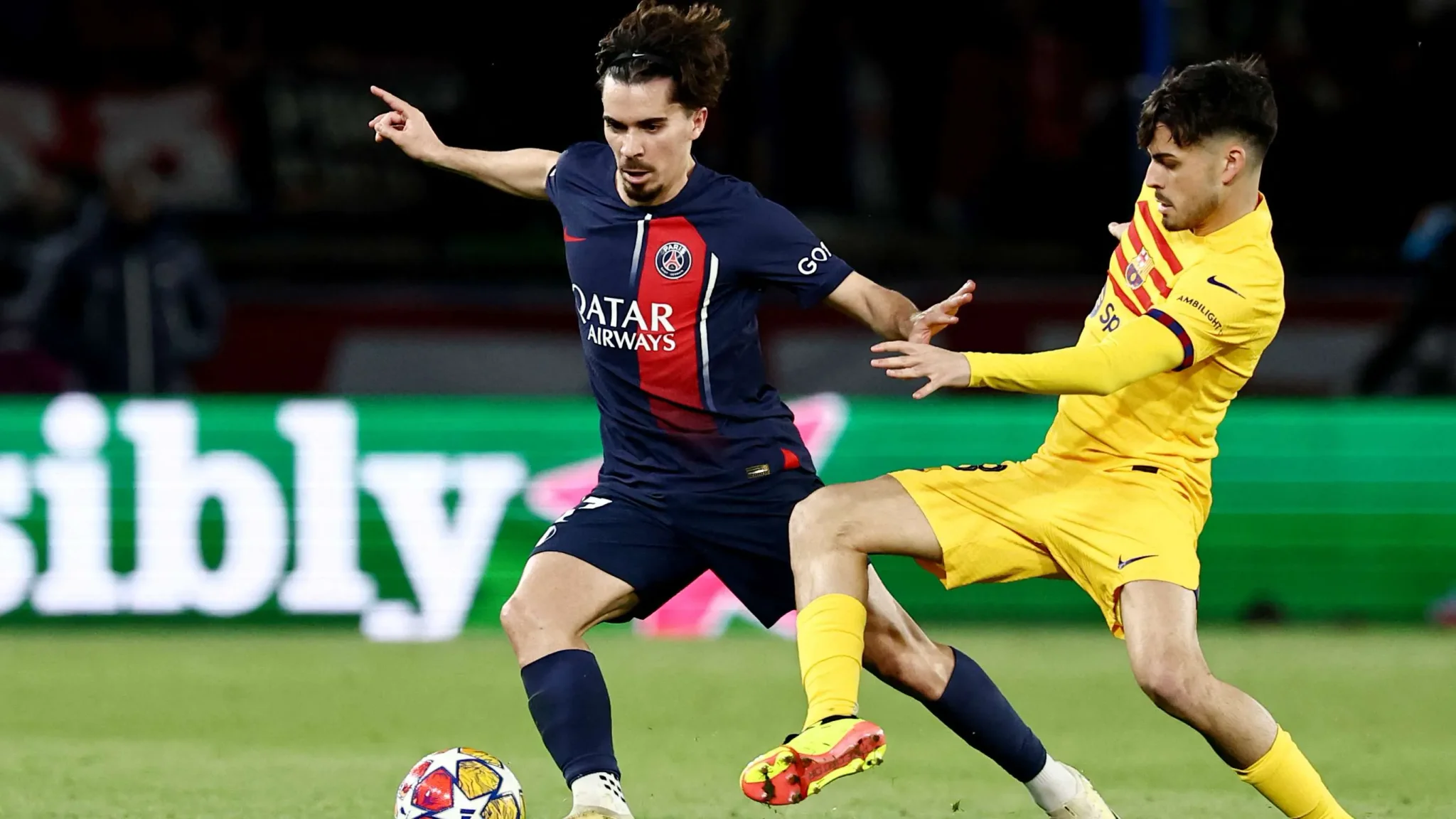 منافسة حامية بين لاعبي وسط باريس سان جيرمان وبرشلونة خلال مباراة دوري أبطال أوروبا مع التركيز على الاستحواذ وتنظيم اللعب.