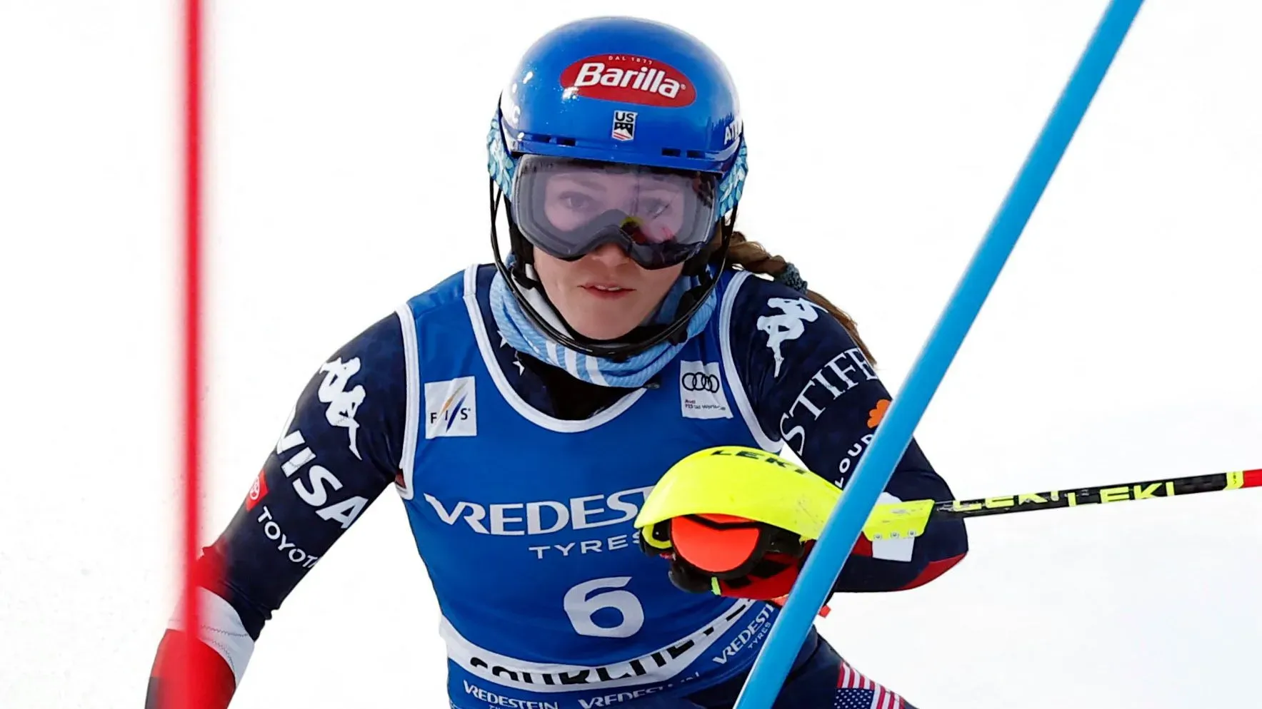 ميكايلا شيفرين تتزلج في سباق التعرج، ترتدي زيها الرسمي، مع التركيز على الأداء رغم آثار الحادث الذي تعرضت له.