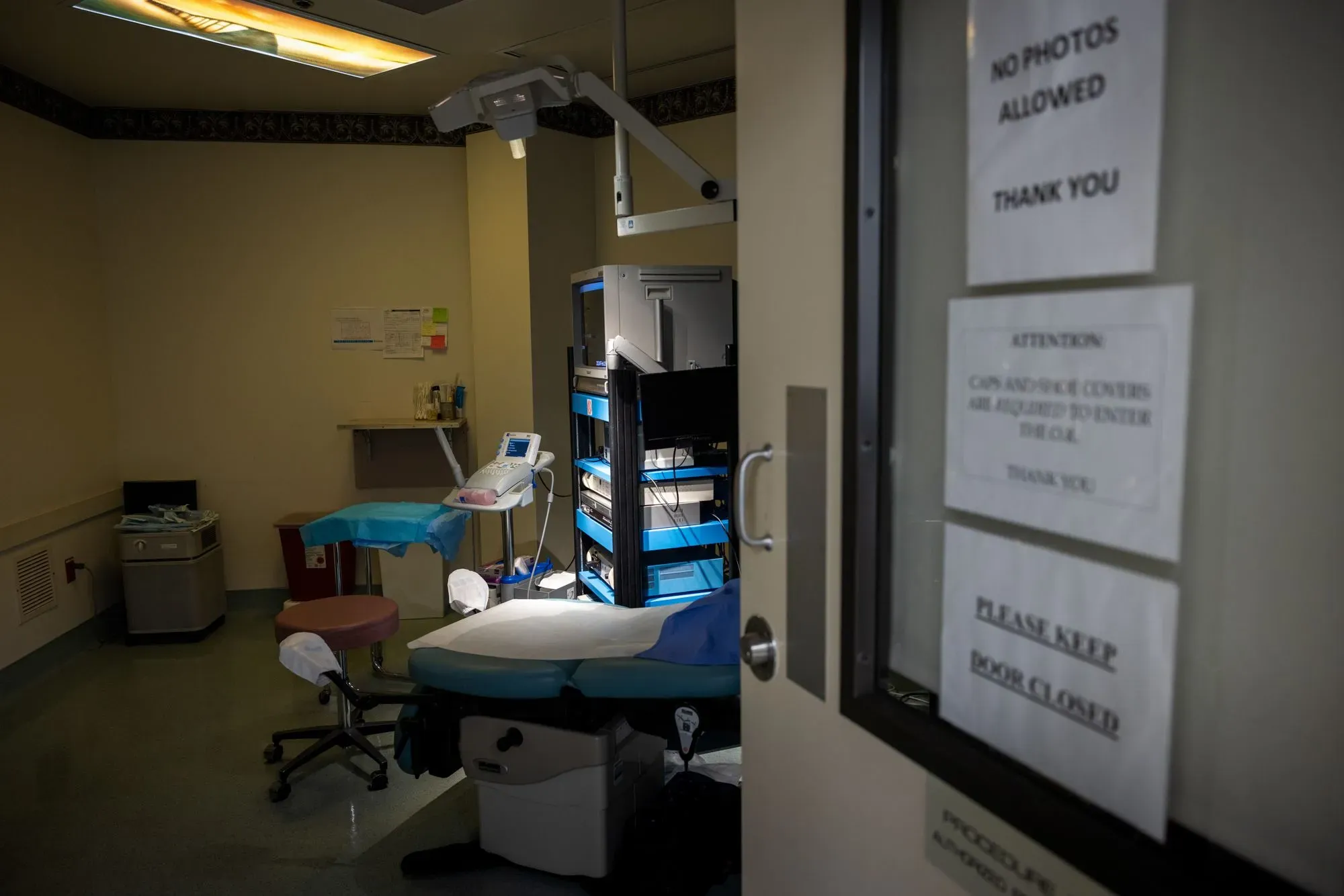 غرفة علاج خصوبة فارغة تحتوي على معدات طبية، مع لافتات تحذر من التصوير. تعكس الصورة التحديات التي تواجهها العائلات العسكرية في الحصول على خدمات الخصوبة.