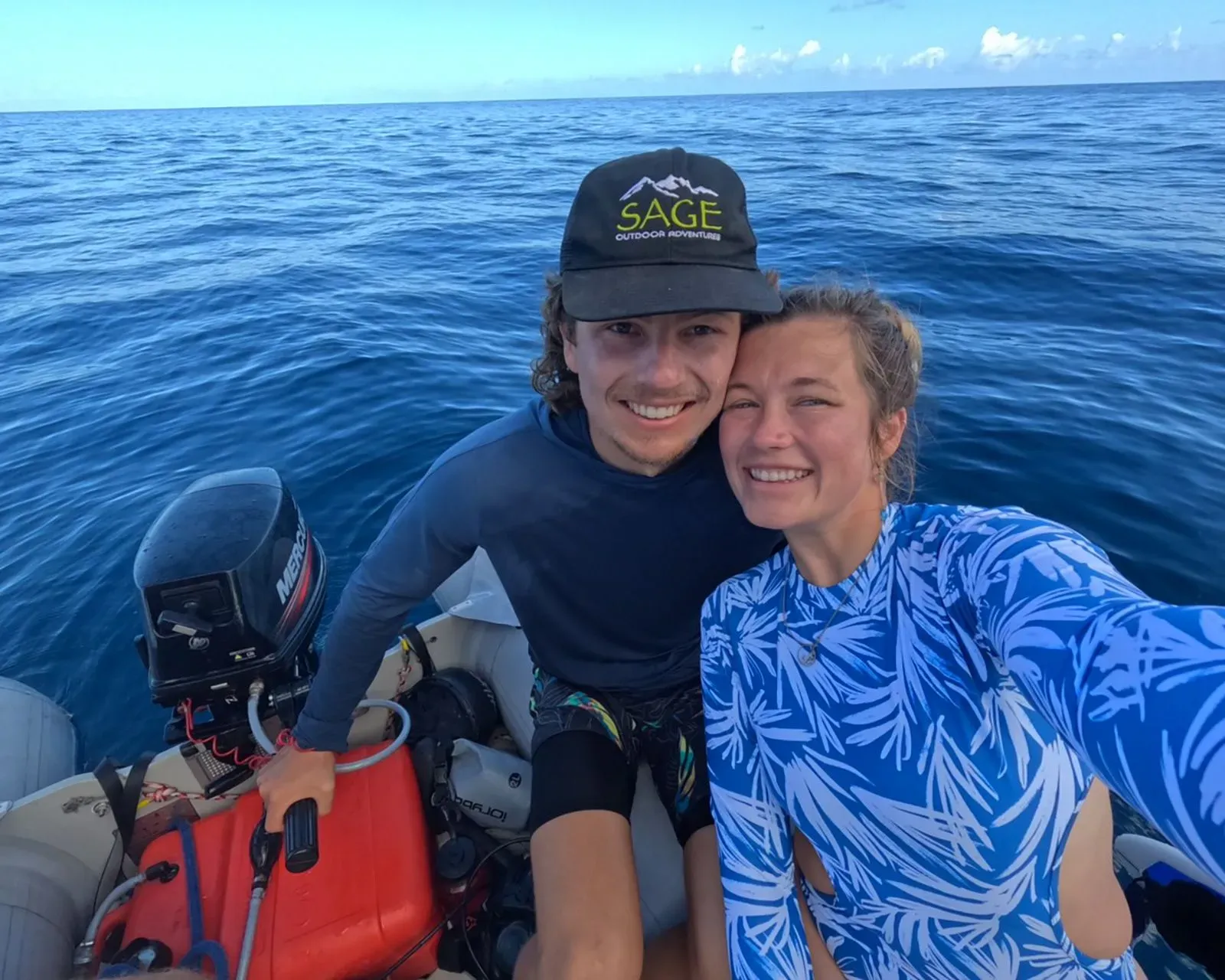 صورة لشاب وشابة مبتسمين على متن قارب في المحيط، يرتديان ملابس سباحة، يعكسان روح المغامرة والإبحار نحو جزر ماركيزاس.