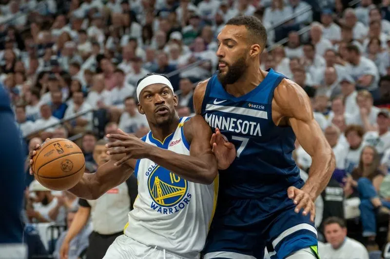 لاعب من فريق جولدن ستيت ووريورز يحاول التمرير بينما يتصدى له لاعب من مينيسوتا تيمبروولفز في مباراة نصف نهائي المؤتمر الغربي.