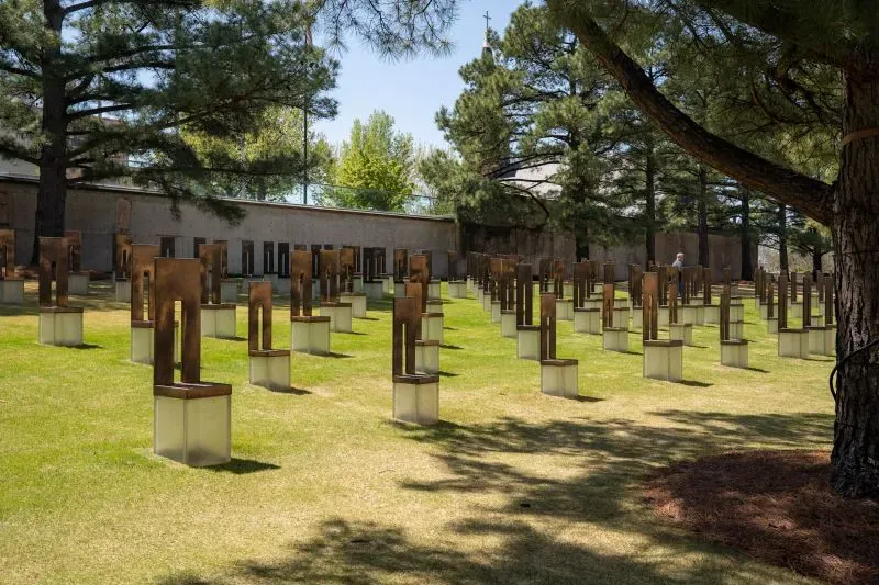 حقل الكراسي الفارغة في النصب التذكاري لأوكلاهوما سيتي، يكرم 168 ضحية بتصميم برونزي، يعكس ذكرى التفجير المدمر.