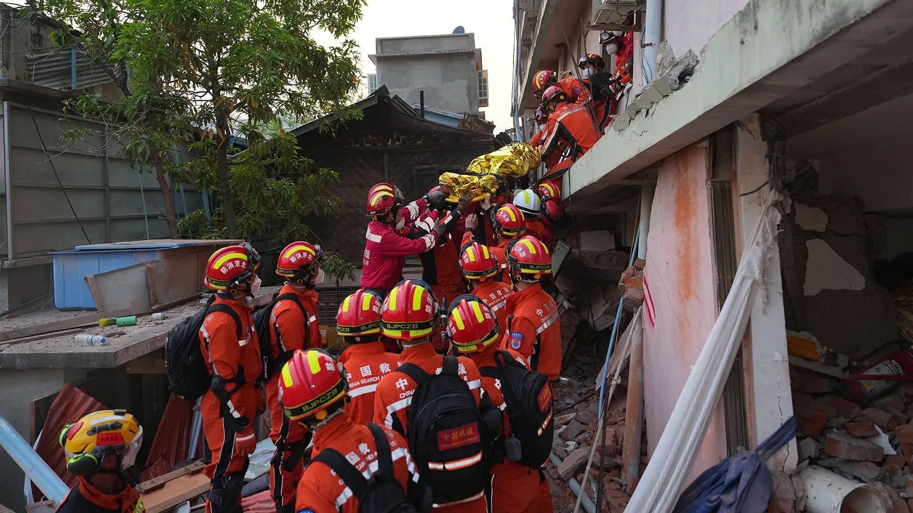 عملية إنقاذ في ميانمار تظهر فرق الإنقاذ وهم يحملون ناجياً من تحت الأنقاض بعد الزلزال المدمر، وسط جهود الإغاثة المستمرة.