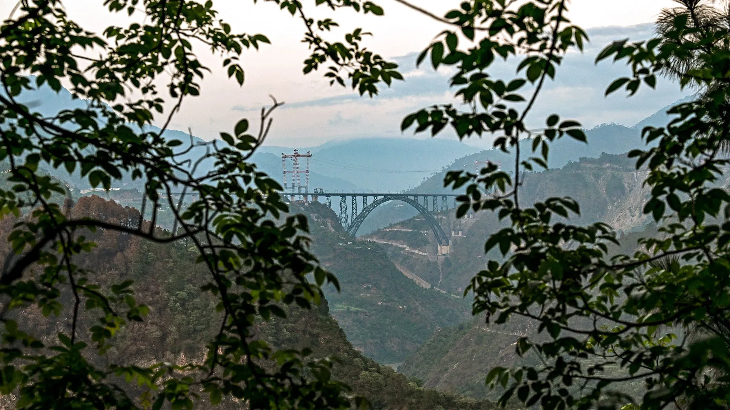 جسر تشيناب المقوس في كشمير، يُعتبر أعلى جسر سكك حديدية في العالم، يربط المنطقة ببقية الهند ويعكس استثمارات الحكومة في البنية التحتية.