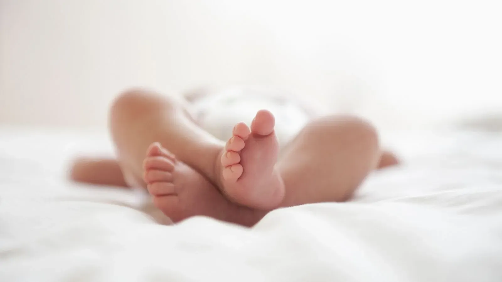 أقدام طفل حديث الولادة مستلقية على سرير، تعكس موضوع الأسماء المحظورة في نيوزيلندا، بما في ذلك اسم "كينغ".