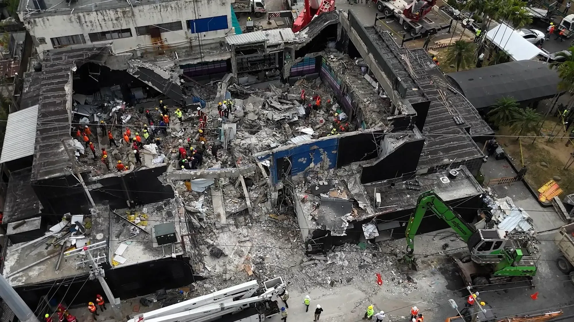 صورة جوية لموقع ملهى جيت سيت الليلي المدمر بعد انهيار سقفه، حيث يعمل عمال الإنقاذ على إزالة الأنقاض والبحث عن الضحايا.