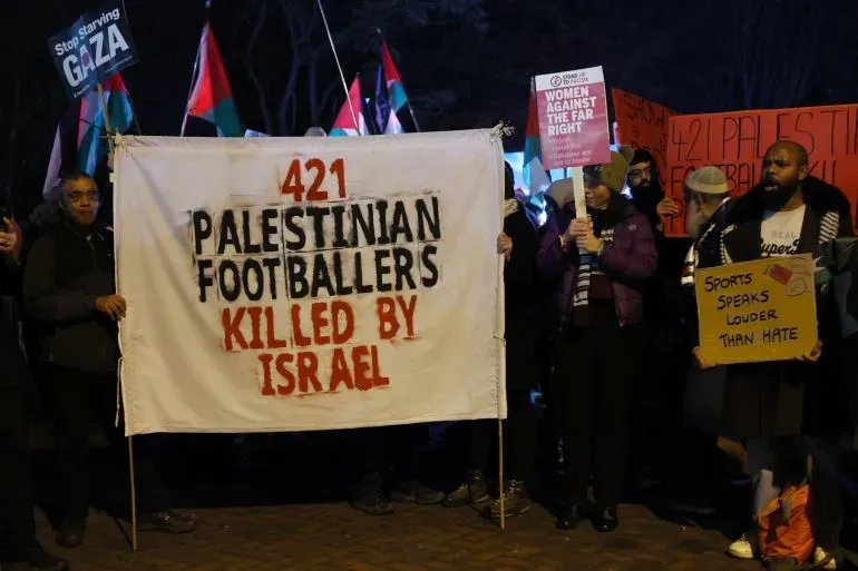 محتجون يحملون لافتة مكتوب عليها "421 لاعب كرة قدم فلسطيني قُتلوا على يد إسرائيل"، خلال تظاهرة لدعم حقوق الفلسطينيين.