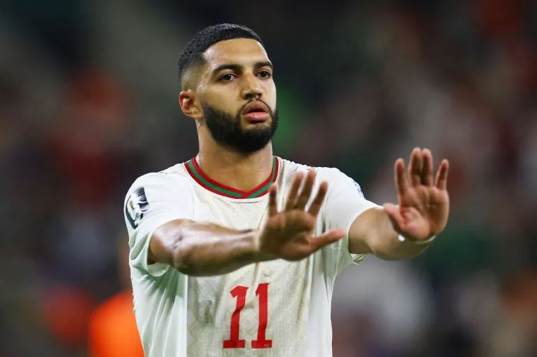 إسماعيل صيباري لاعب منتخب المغرب يرتدي القميص رقم 11 أثناء مباراة كأس العالم، يعبر عن تركيزه رغم غيابه المتوقع بسبب إصابة أوتار الفخذ.